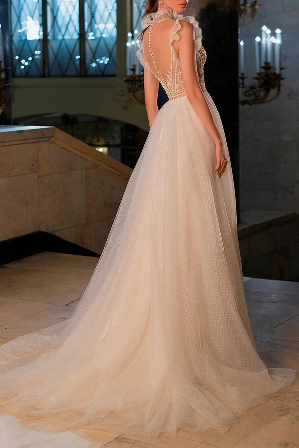 Un abito da sposa bohémien con illusione di filo e perline scintillanti sulla scollatura
